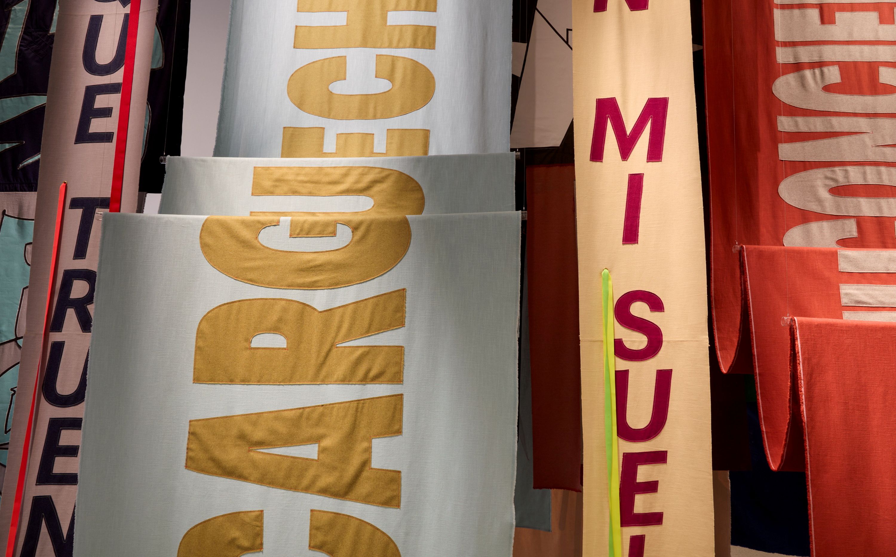 A close-up of textile banners emblazoned with text featured in Nadia Hernandez's installation at AGNSW.
