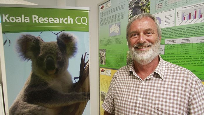 Dr Alistair Melzer with a poster of a koala