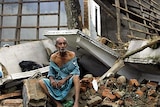 A 70-year-old Sri Lankan man sits among the ruins of his home in Galle