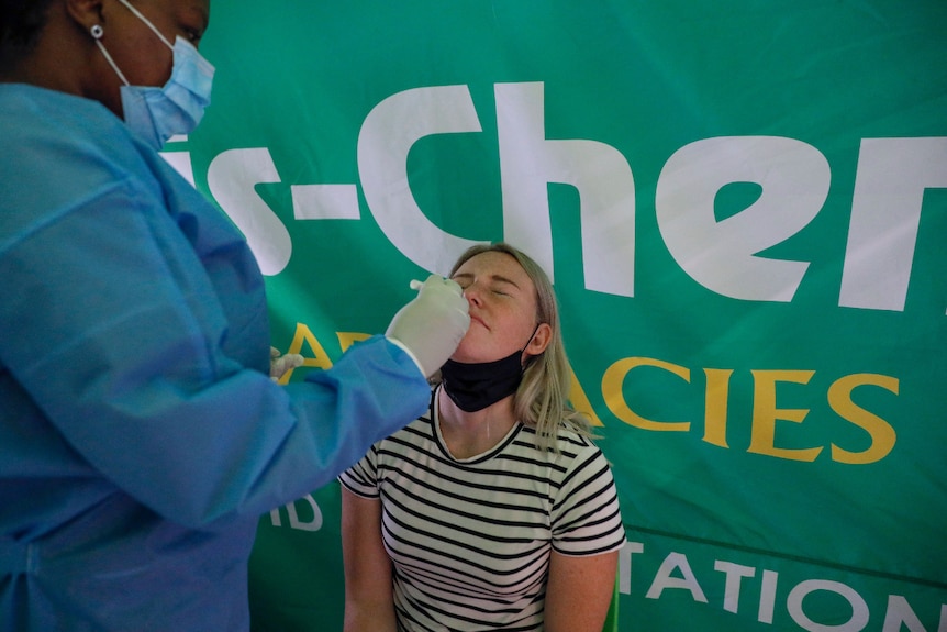 A woman gets a PCR test from a healthcare worker in Johannesburg.