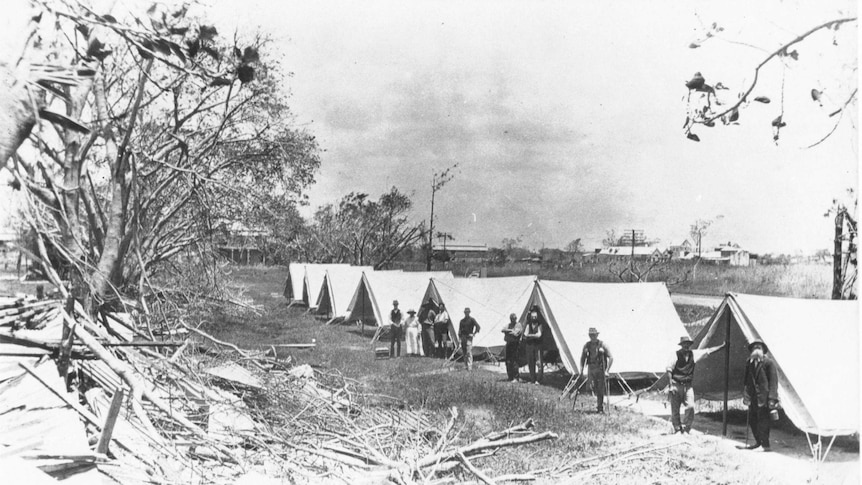 A line of tents with people standing in front of them