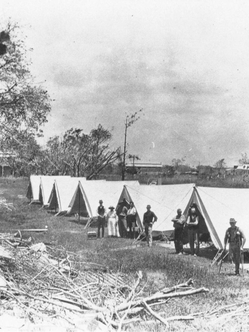A line of tents with people standing in front of them