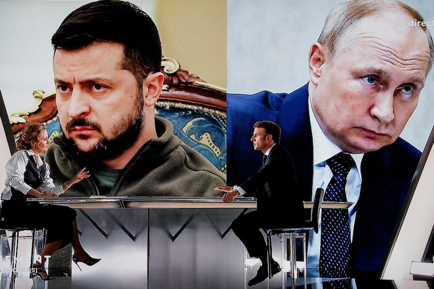 French president Emmanuel Macron speaks with a journalist in front of Mr Zelenskyy and Mr Putin.