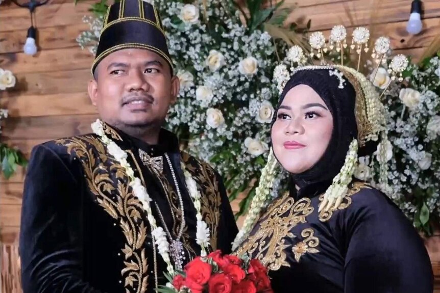 An Indonesian bride and groom pose for a photo