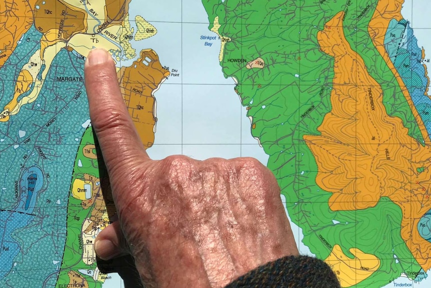 Close up of an old man's hand pointing to a map of North West Bay