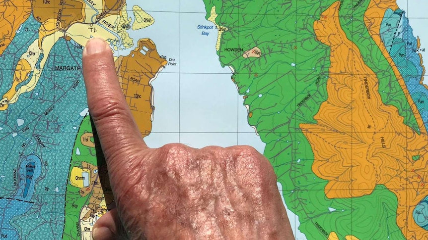 Close up of an old man's hand pointing to a map of North West Bay