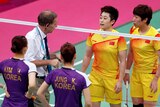 Tournament referee Torsten Berg speaks to players from China and South Korea during the badminton.