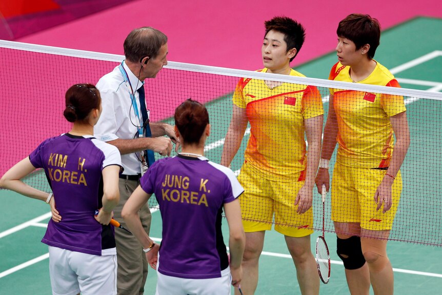 Tournament referee Torsten Berg speaks to players from China and South Korea after both teams appeared determined to lose.