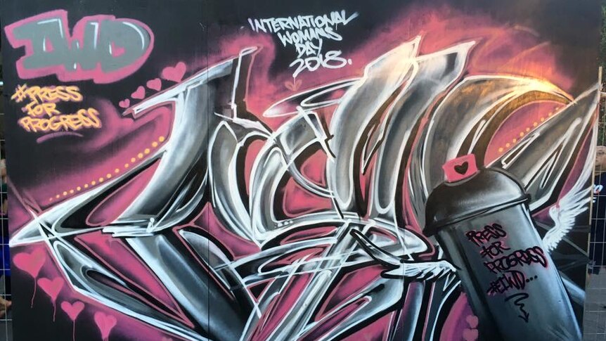 A piece of spray-paint art in greys and pinks to celebrate International Women's Day 2018.
