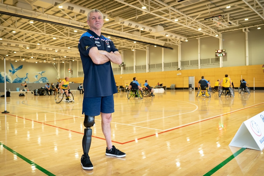 A man with one prosthetic leg standing on a basketball court