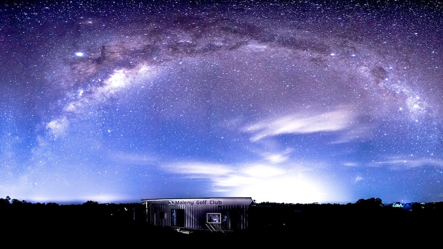 A container shed sits in the forground of the photo with a sign, 'Maleny Golf Club' as the Milky Way shines overhead.