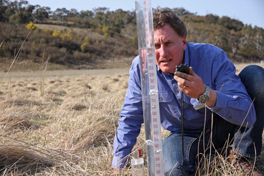 Luke Peel measures the water infiltration rate in the soil.