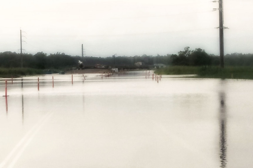 Flooded Cattle Creek, south of Ingham, in north Queensland on March 28, 2018, continues to flow over the Bruce Highway.