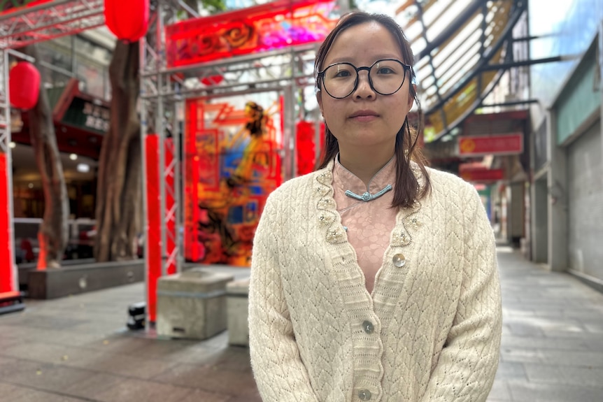 A woman stands in a street.