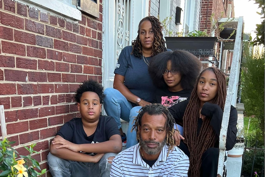 Trevilin J. Allen and his family sit on the stairs