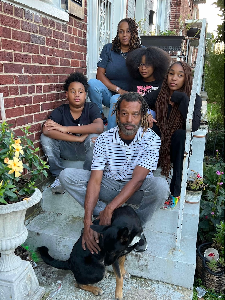 Trevilin J. Allen and his family sit on the stairs