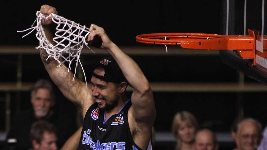 Man of the moment ... retiring Breakers veteran Paul Henare cuts the net in front of his triumphant team-mates.