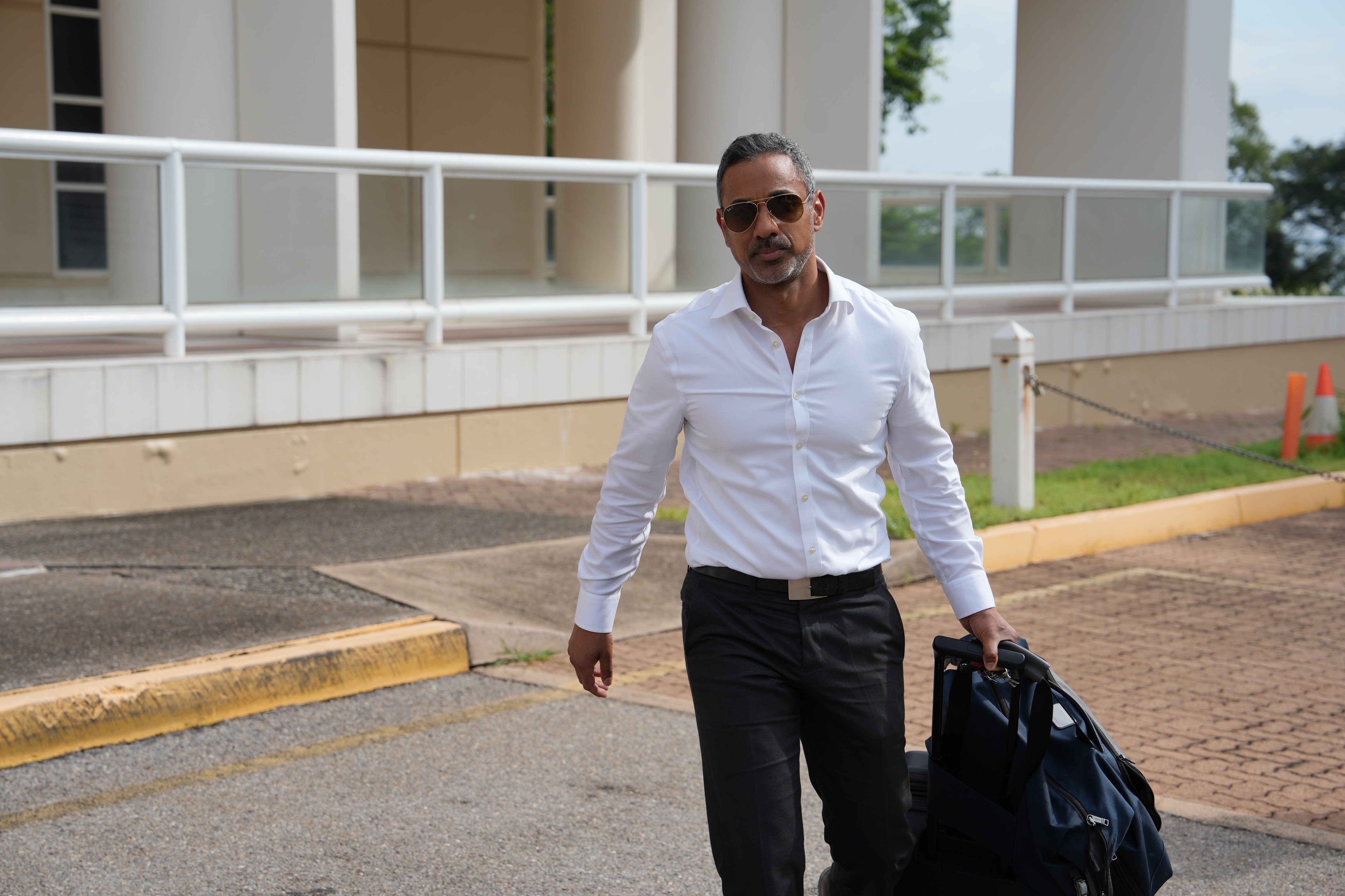 Um homem usando óculos escuros enquanto se afasta da quadra.