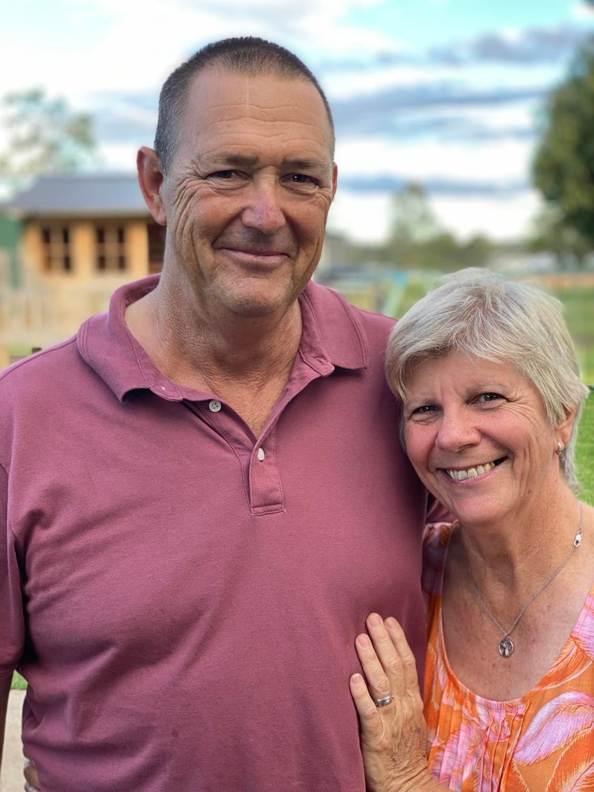 a middle aged man and woman smile at the camera