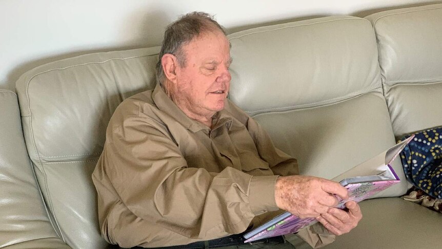 Brian Perry sits on a couch at his home.