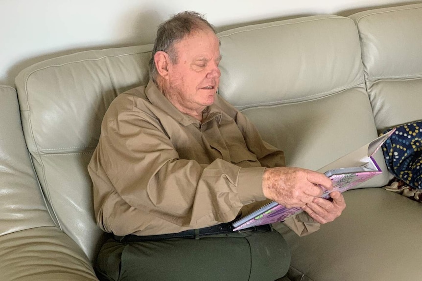 Brian Perry sits on a couch at his home.