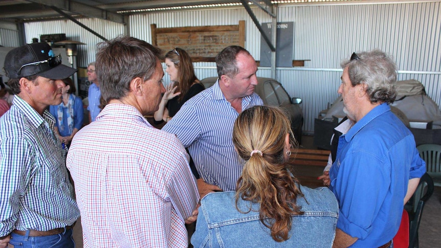 Barnaby Joyce stands with his hands on his hips talking to a group of farmers in Broken Hill
