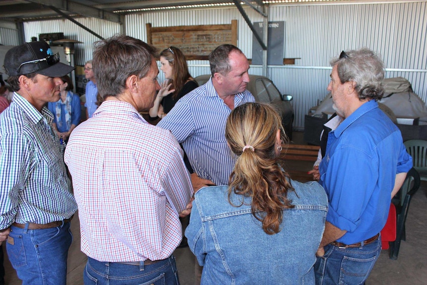 Barnaby Joyce stands with his hands on his hips talking to a group of farmers in Broken Hill