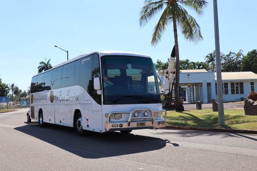 A coach bus driving on a street in daylight