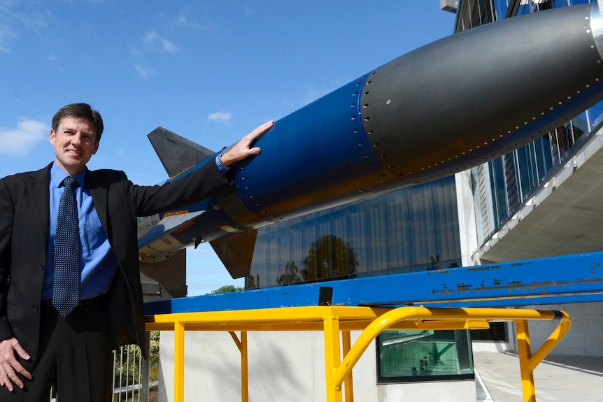 Professor Russell Boyce stands next to the scramjet.