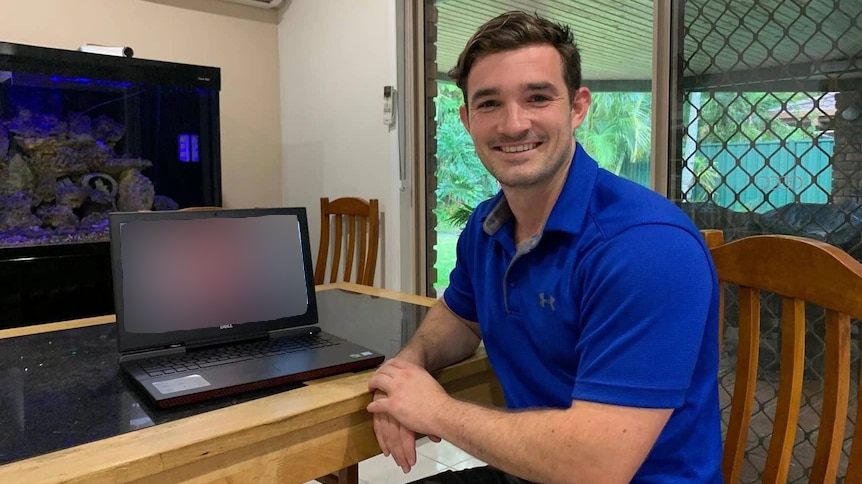 man sitting next to computer