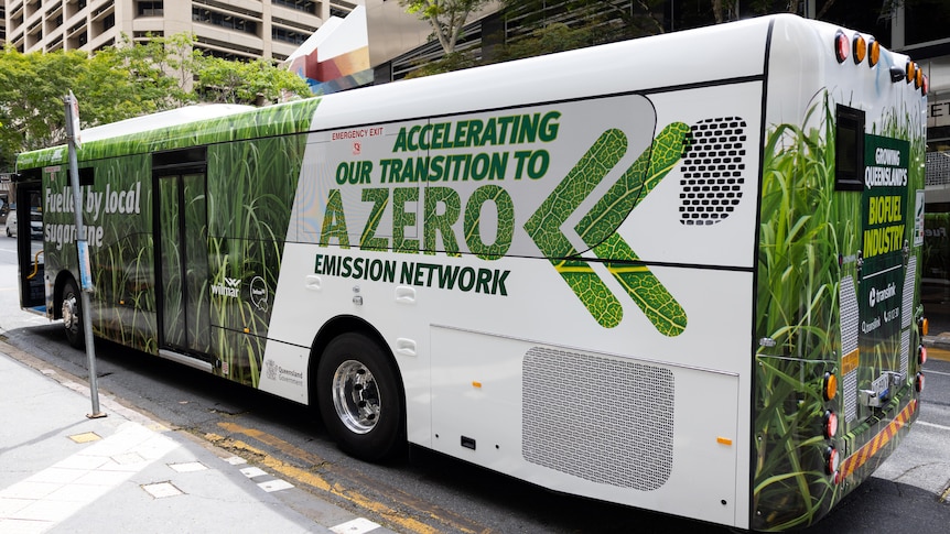 A bus with green writing saying accelerating our transmission to zero emissions on the side.