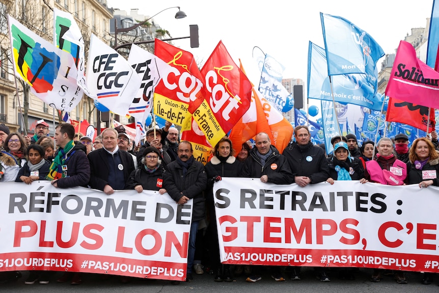 法国工会领导人举着抗议提高退休年龄的标语牌。