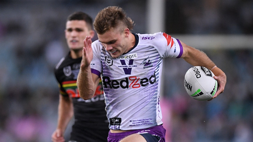 Ryan Papenhuyzen runs with his head down, a rugby ball tucked under one arm