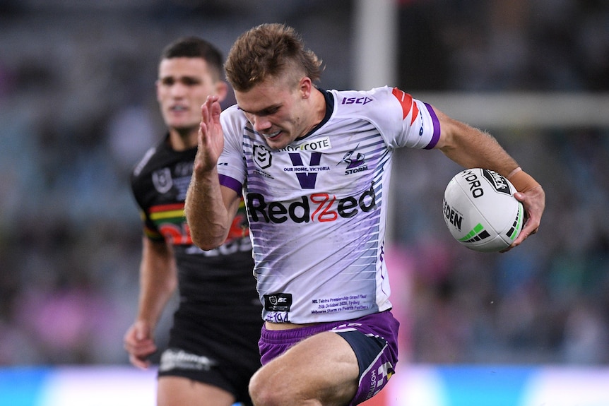 Ryan Papenhuyzen runs with his head down, a rugby ball tucked under one arm