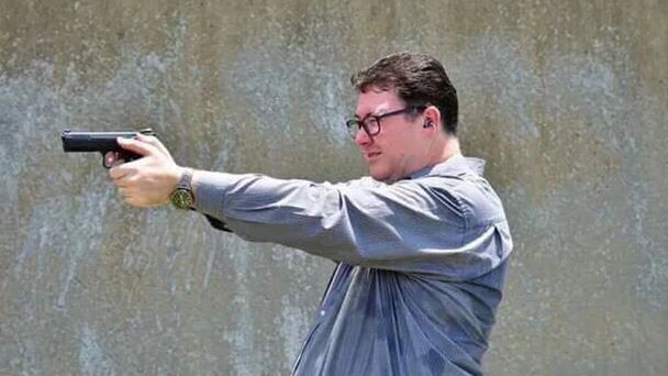 Federal MP George Christensen aims a handgun.