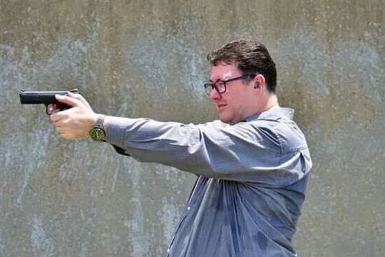 Federal MP George Christensen aims a handgun.