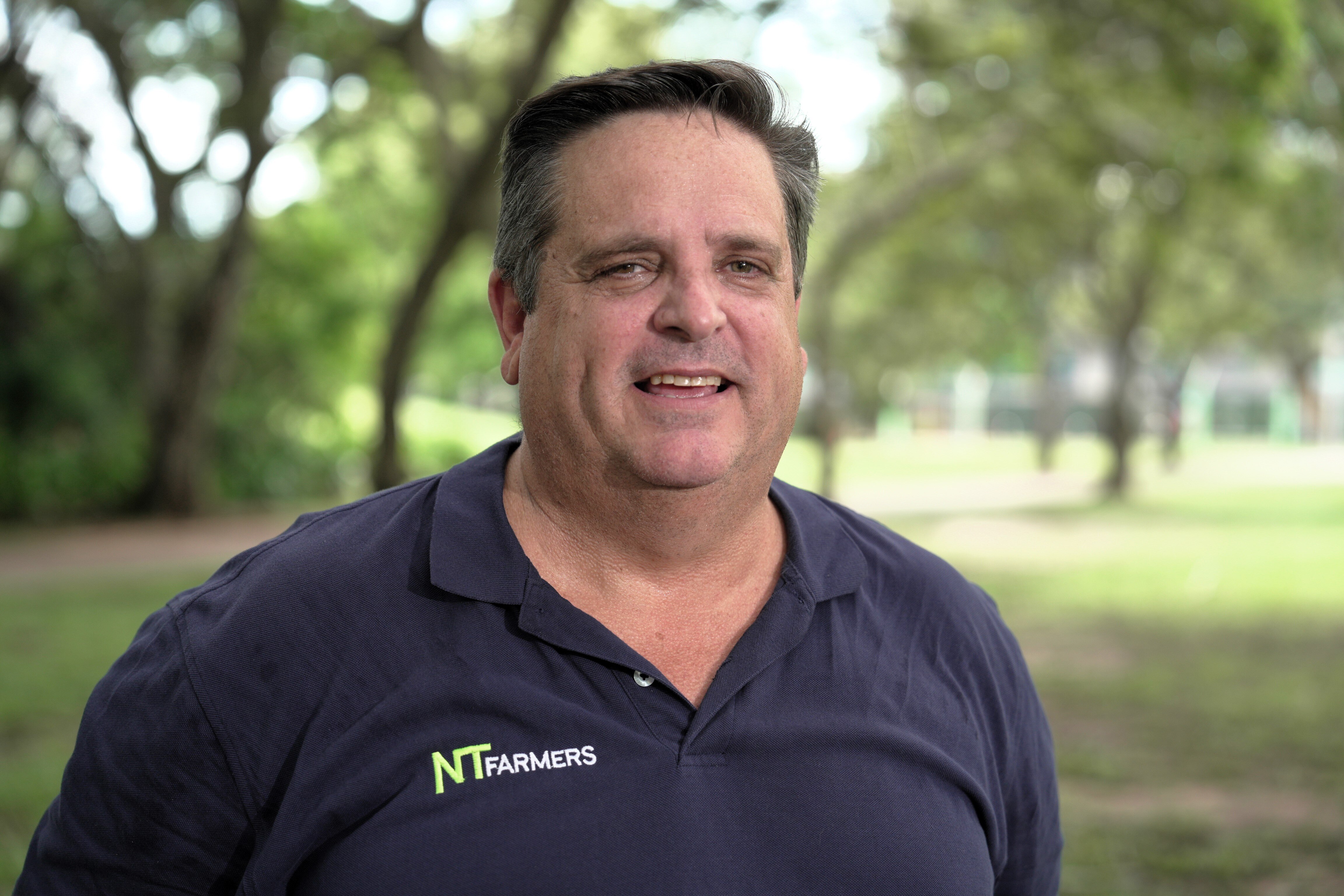 A man smiling standing outside.