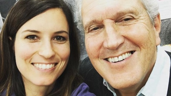 A woman and an older man smile in a selfie shot.