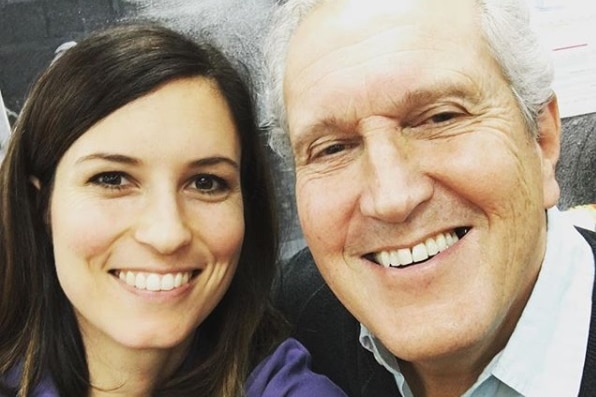 A woman and an older man smile in a selfie shot.