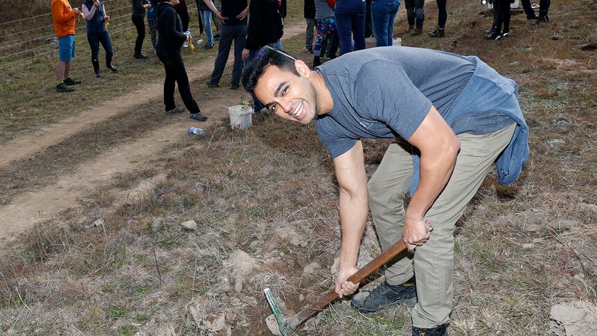 Man using a pick axe in the ground