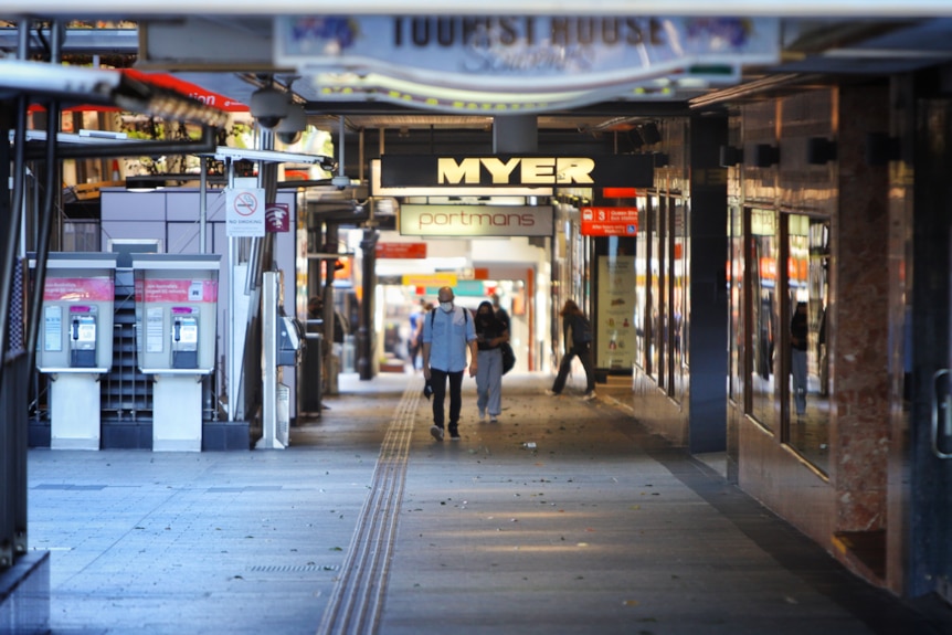 Man walks through empty mall.