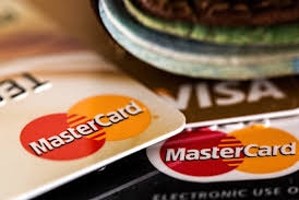 A pile of MasterCard and VISA cards piled on top of each other.
