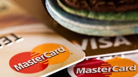 A pile of MasterCard and VISA cards piled on top of each other.