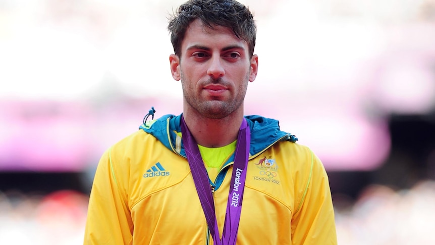 Mitchell Watt stands on the podium with his silver medal he won for the men's long jump.