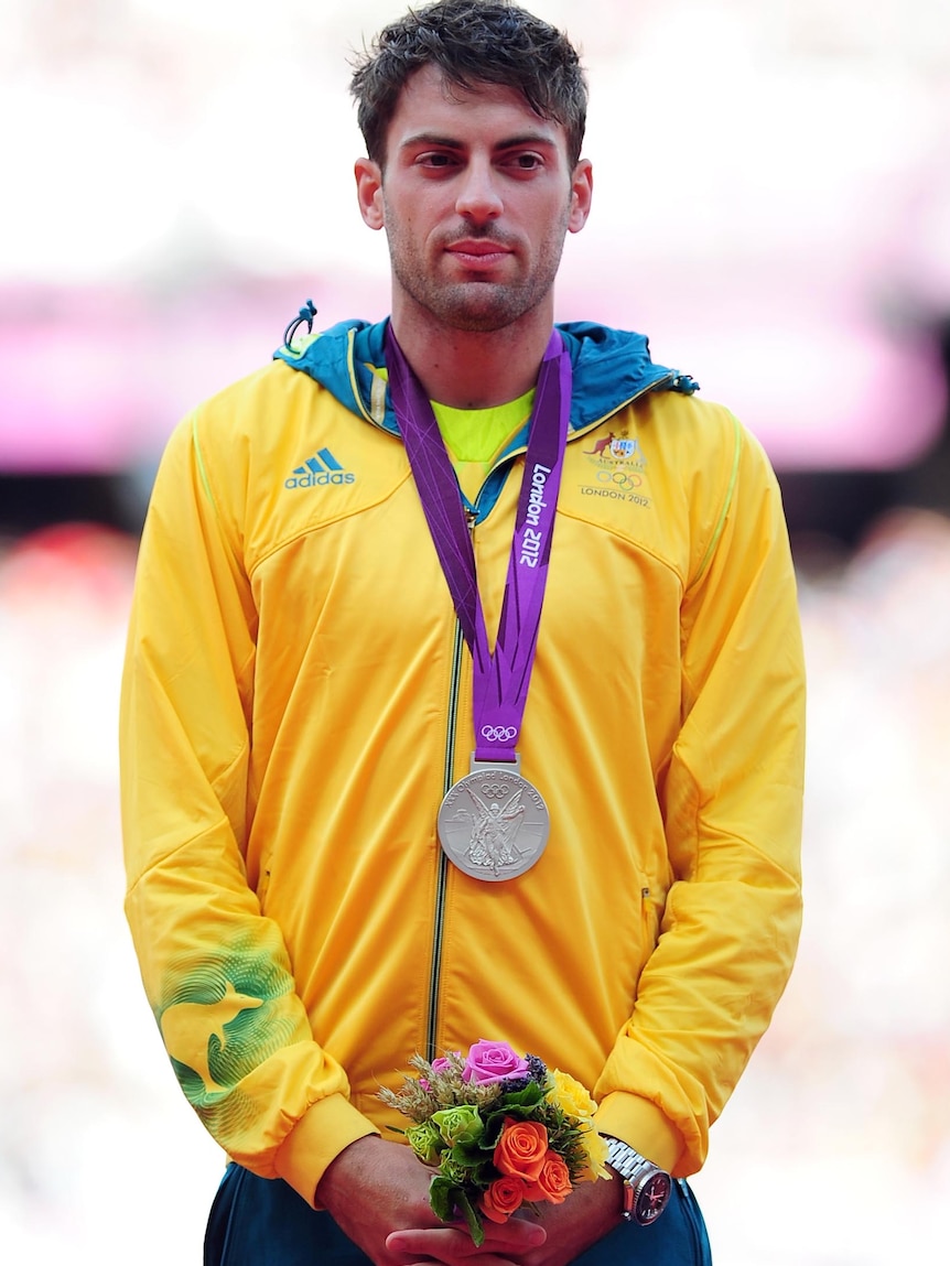 Mitchell Watt stands on the podium with his silver medal he won for the men's long jump.