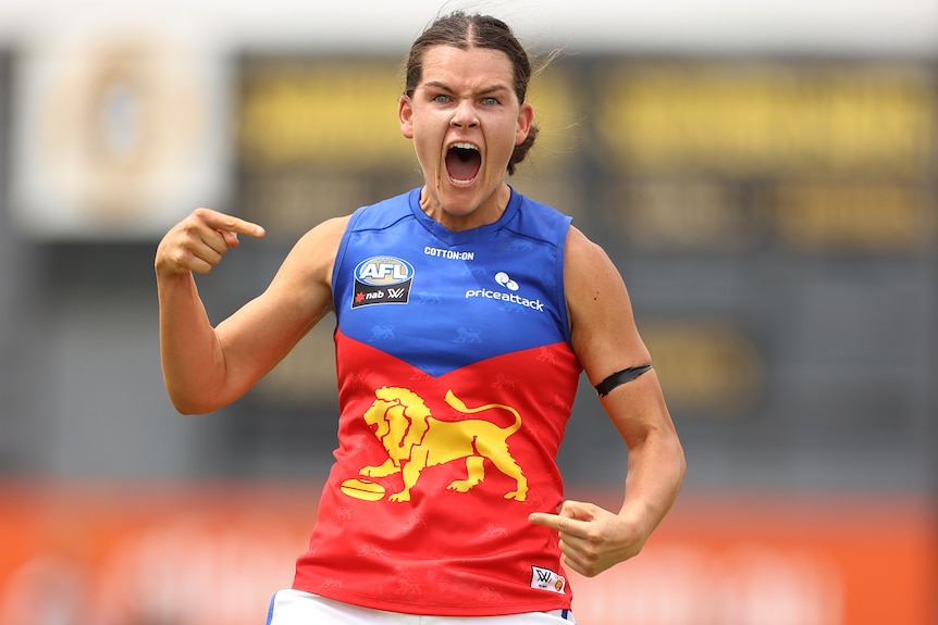 A Brisbane Lions AFLW player screams out as she celebrates kicking a goal against St Kilda.