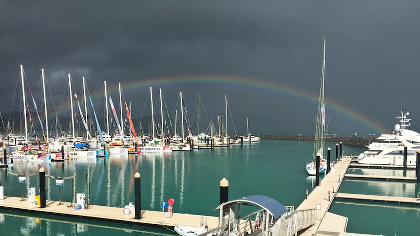 Beautiful colourful rainbow lights up a darkened sky in the Whitsundays