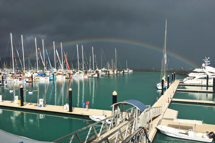 Beautiful colourful rainbow lights up a darkened sky in the Whitsundays