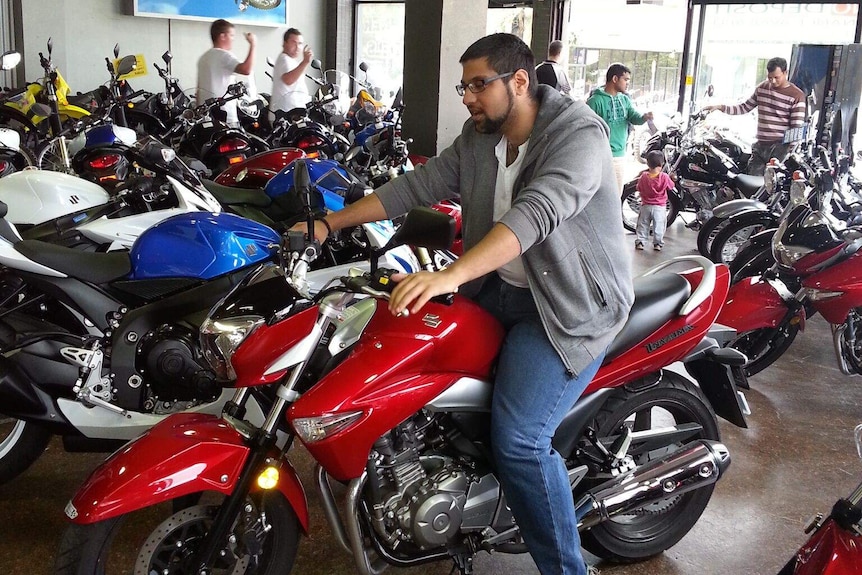 Richard on a motorbike in a motorcyle shop.