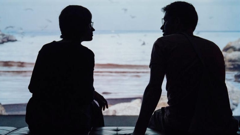 Silhouette of couple talking seriously for a story on how to have a tough conversation